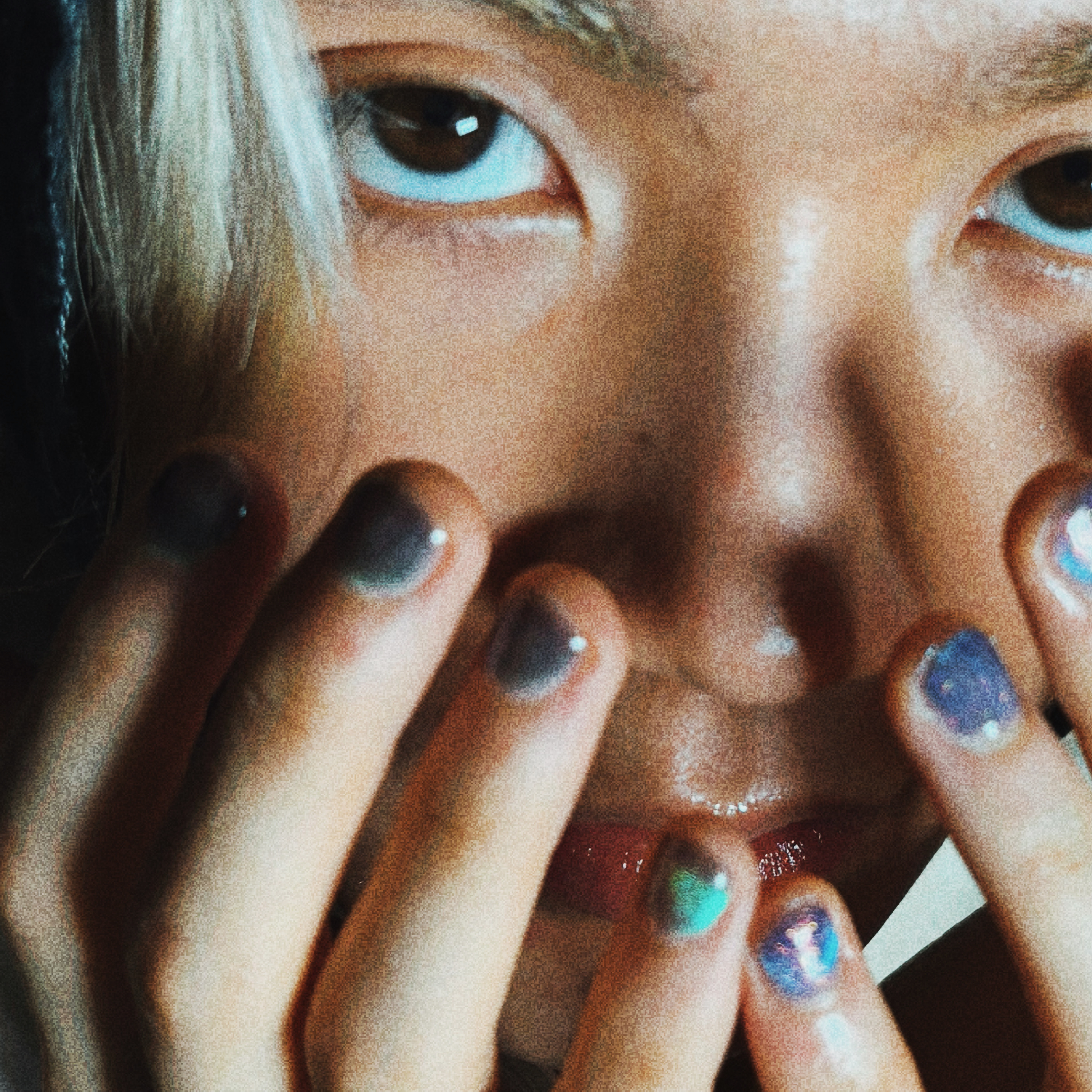 Eye close-up with multicolored nails