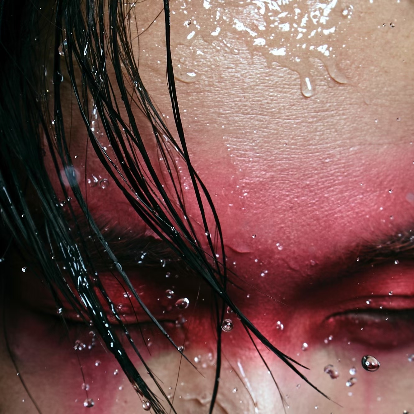 Face close-up with water droplets and red light